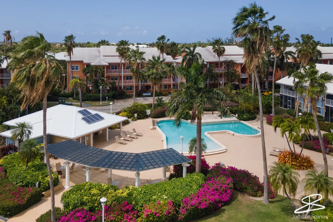 Pool deck and shaded cabana at Britannia, with the surrounding low-rise condominium buildings and palms